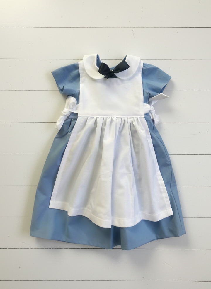 Children's dress with blue and white color scheme on a light wooden background