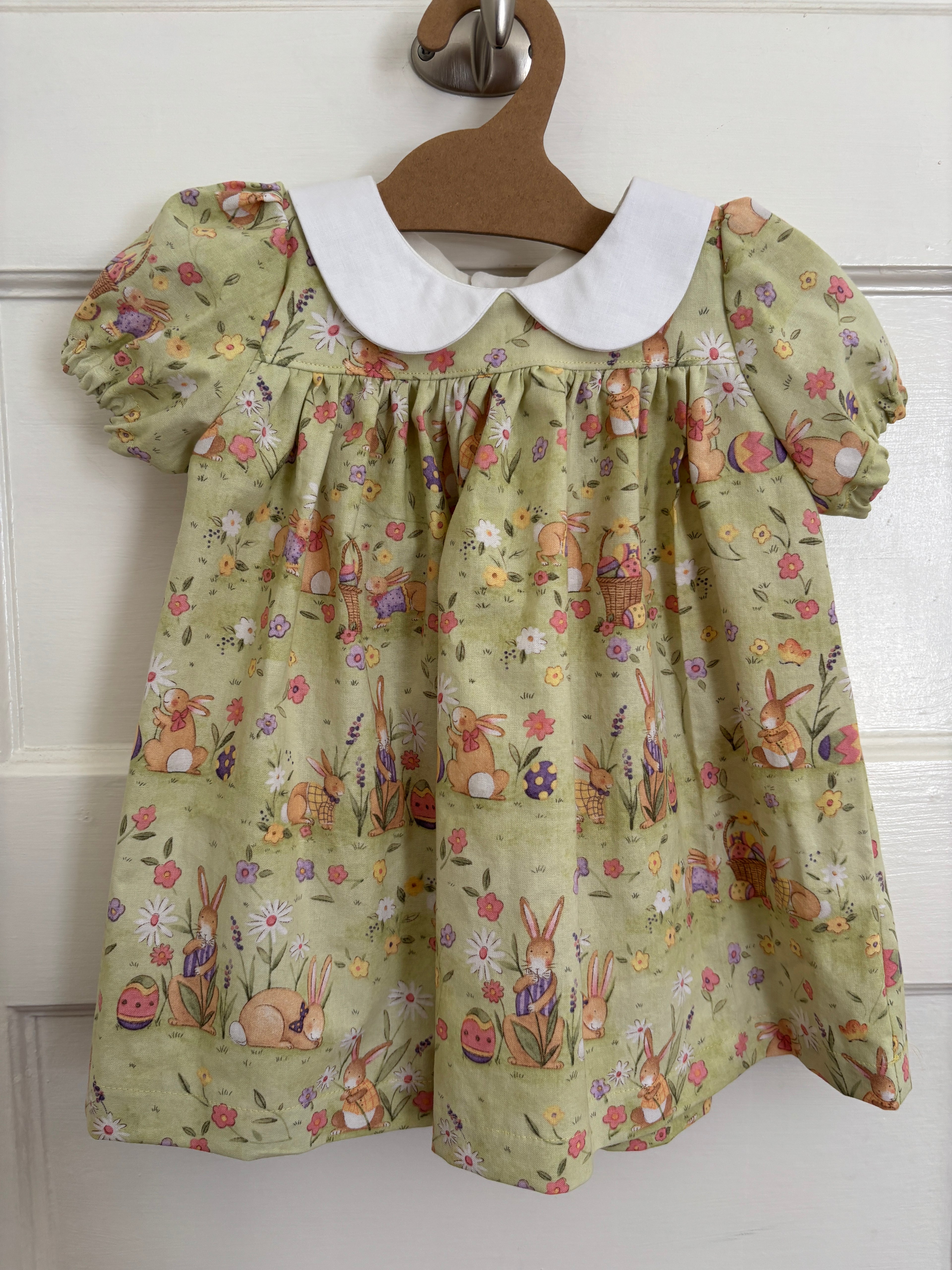 Floral dress on a hanger against a white background