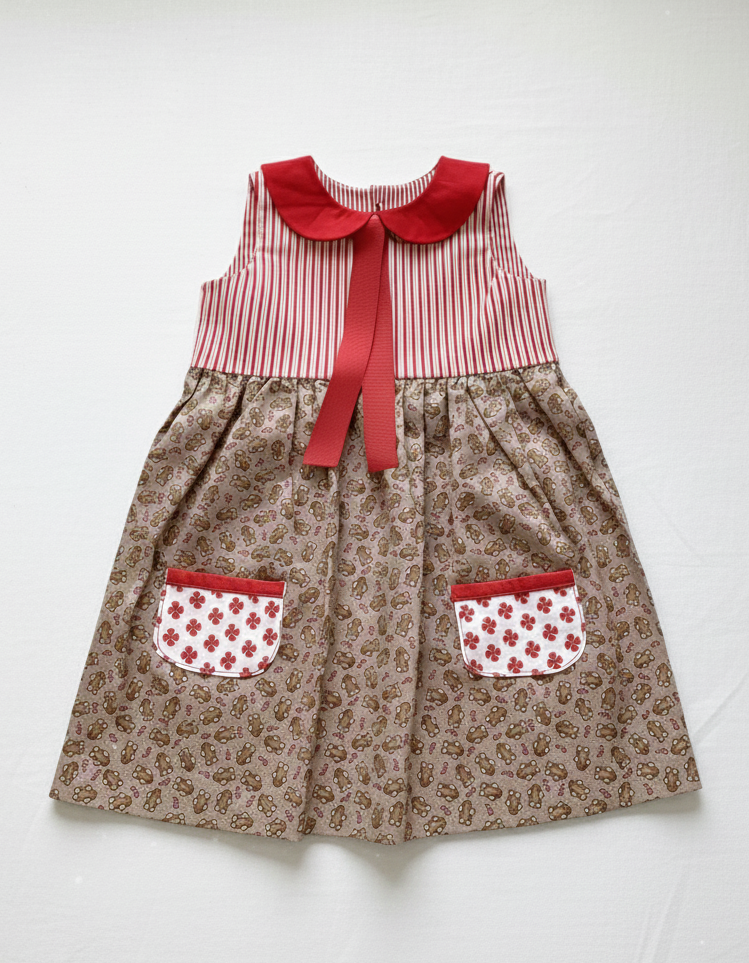 Children's dress with red collar and pockets on a white background