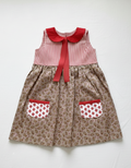 Children's dress with red collar and pockets on a white background