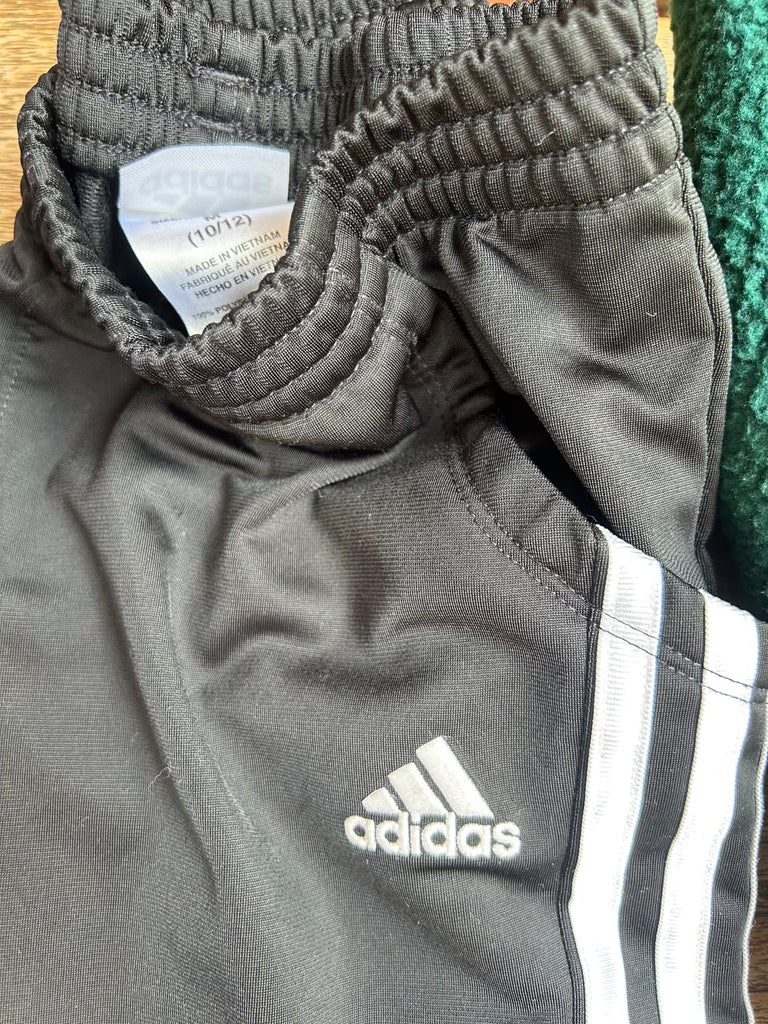 Gray/black Adidas tracksuit with a close-up of the waistband and brand logo.