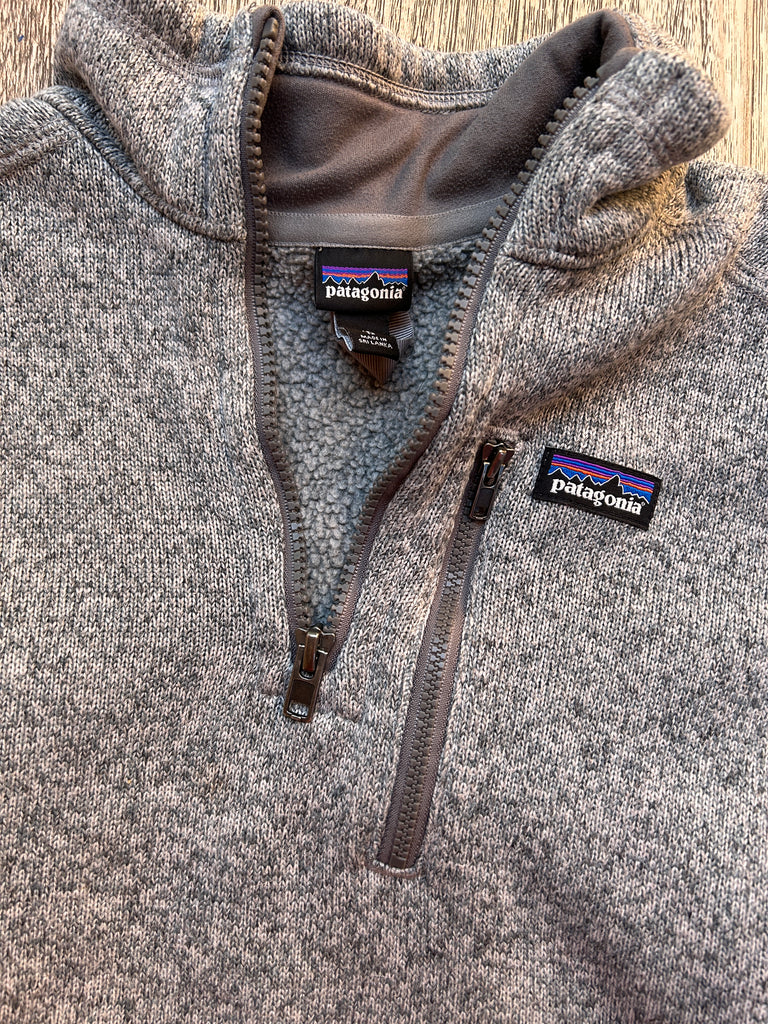 Gray fleece jacket with Patagonia logo on a wooden surface