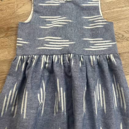 Blue dress with white pattern on a wooden surface