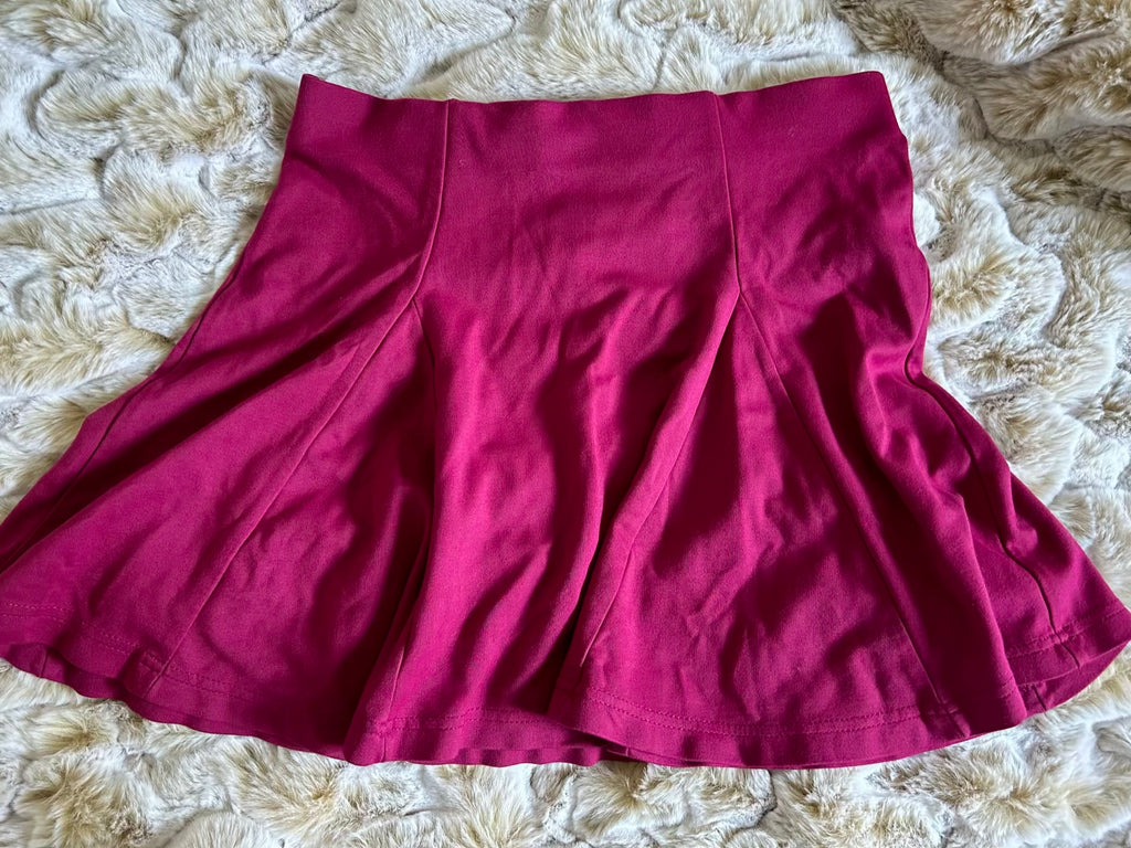 Maroon skirt on a textured beige surface