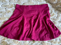 Maroon skirt on a textured beige surface