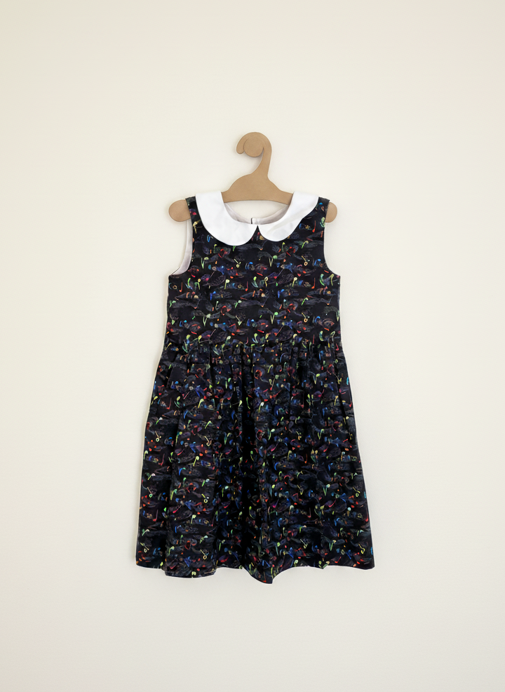 Black floral dress with white collar on a hanger against a white background