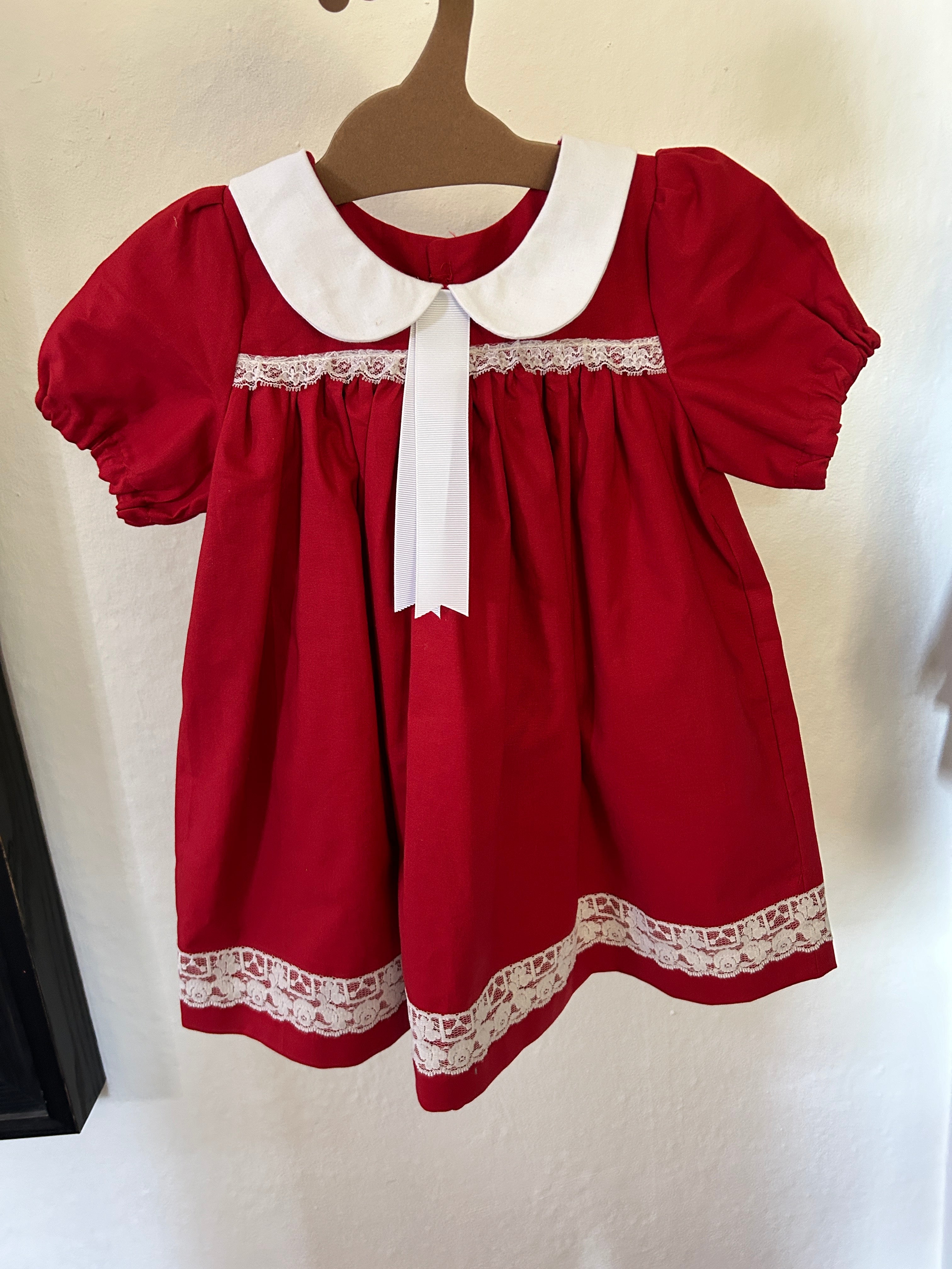 Red dress with white lace details on a plain background