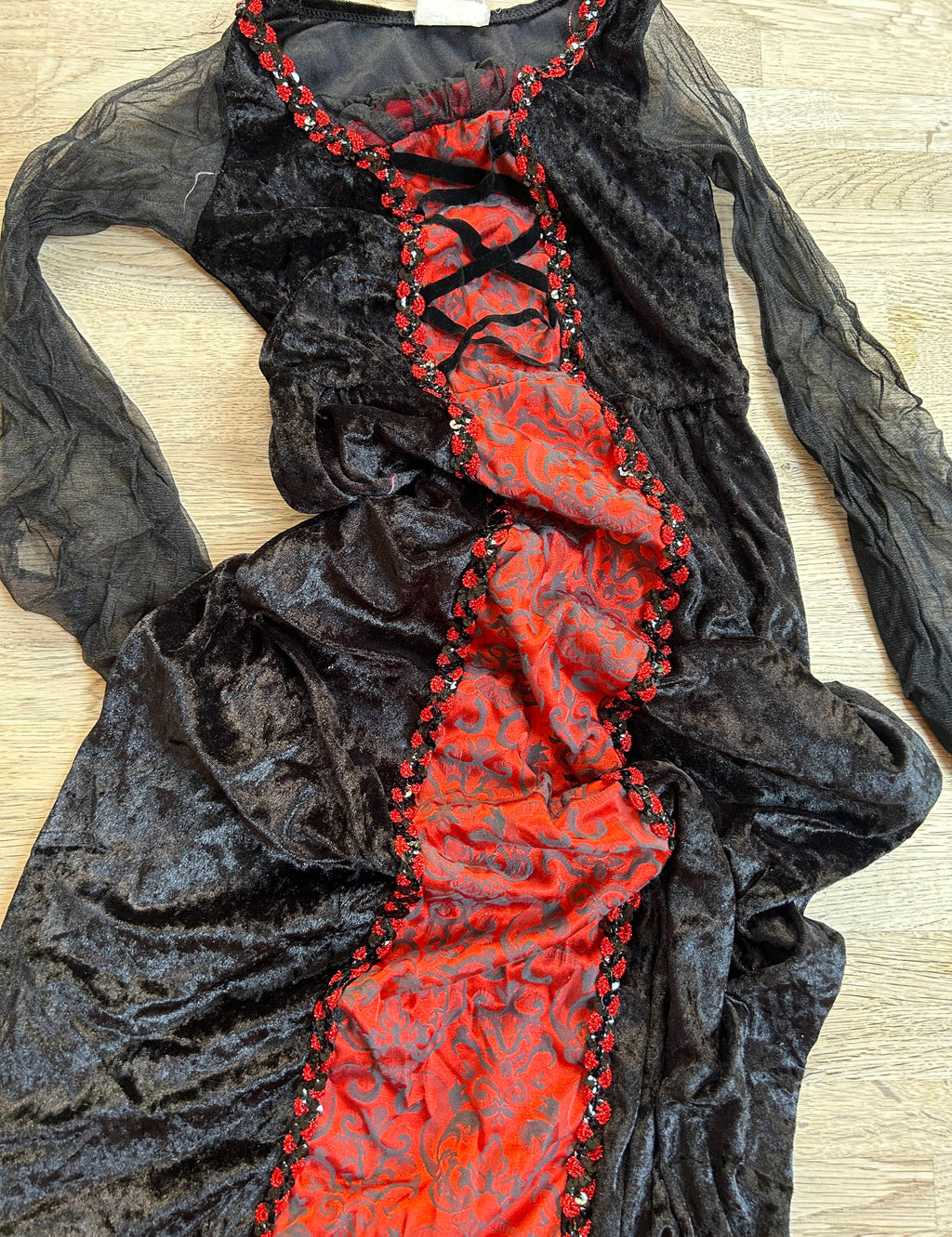 Long black and red dress with red lace detailing, showing signs of wear.