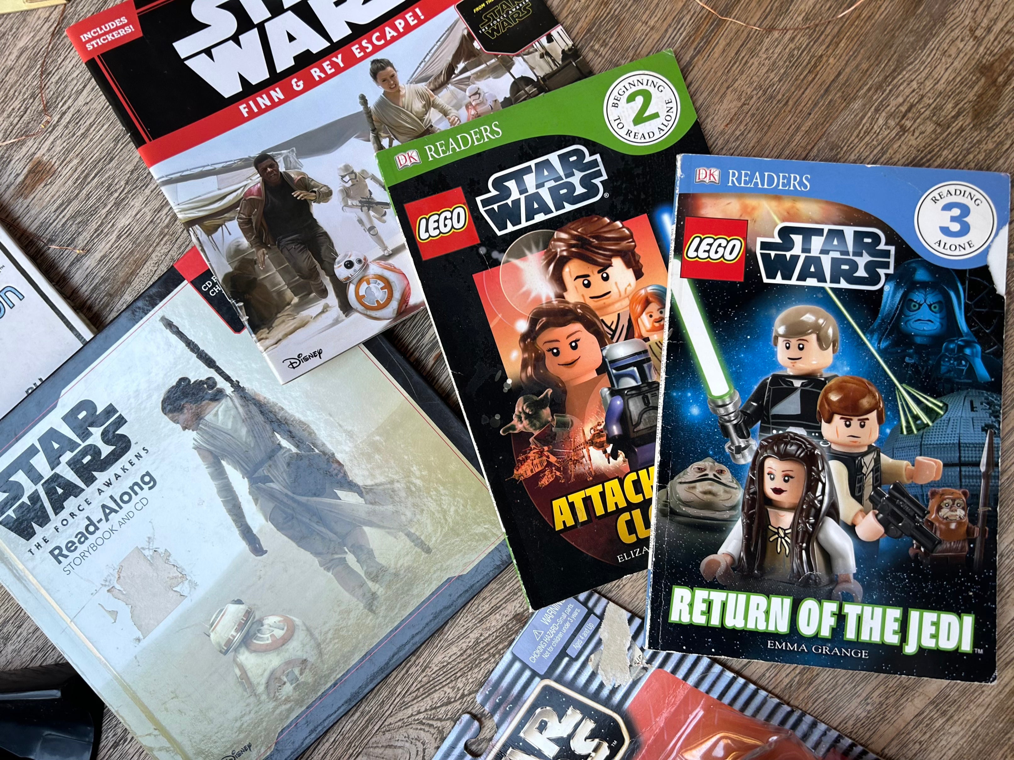 Collection of Star Wars books and readers on a wooden surface