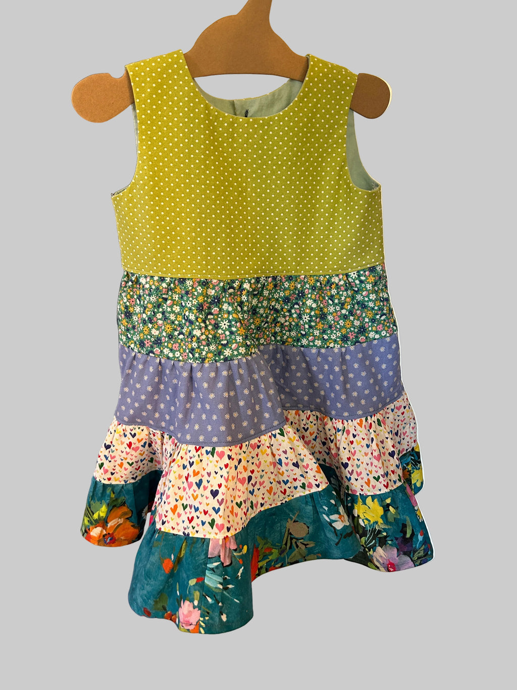 Colorful patchwork dress on a mannequin with a white background