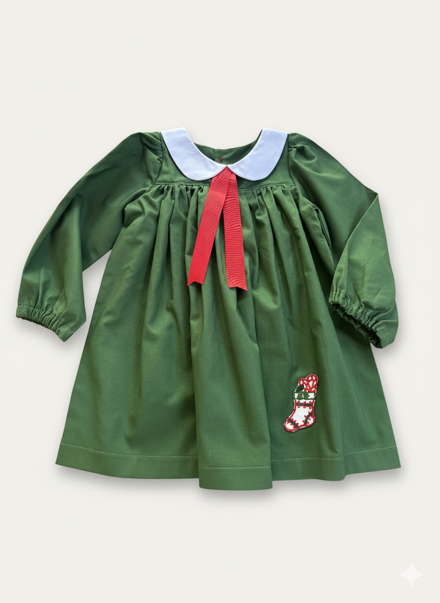 Green dress with red ribbon and white collar on a light gray background