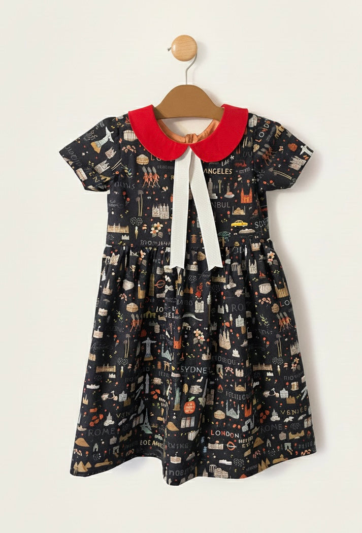 Children's dress with a red collar and black pattern on a white background